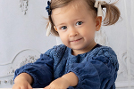 Klein kind mit Zöpfen im blauem Kleid